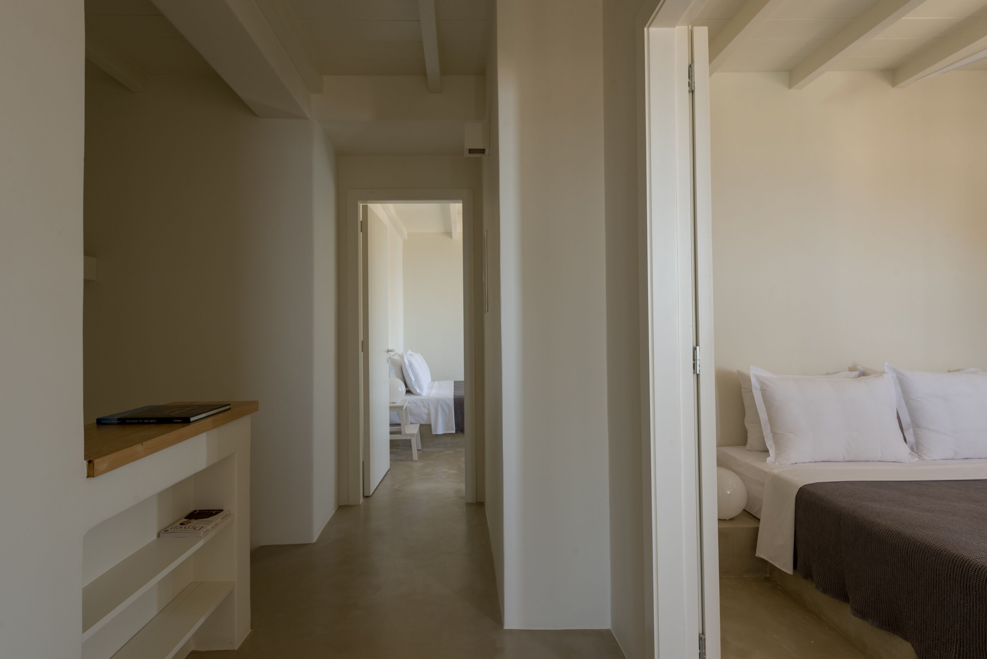 Quarto de hotel com uma cama, mesa de cabeceira e guarda-roupa.