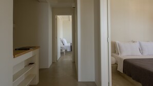 A hotel room with a bed, a bedside table, and a wardrobe. - Andros Tessera (Andros)