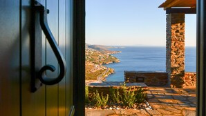 A stone pathway leading to a stone building with a view of the sea. - Andros Tessera (Andros)