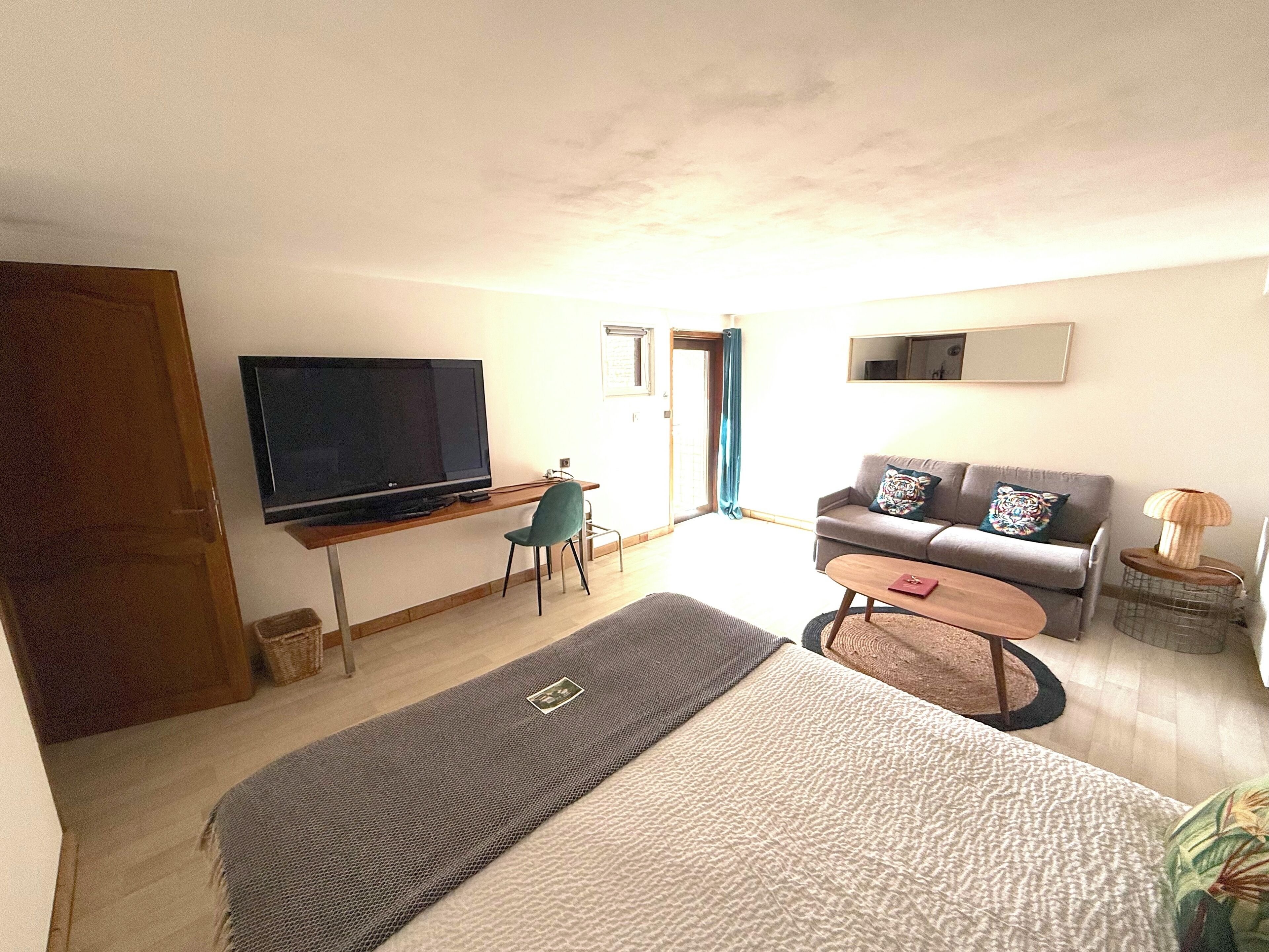 Una sala de estar moderna con un televisor de pantalla plana, un sofá, una mesa de centro y una cama.