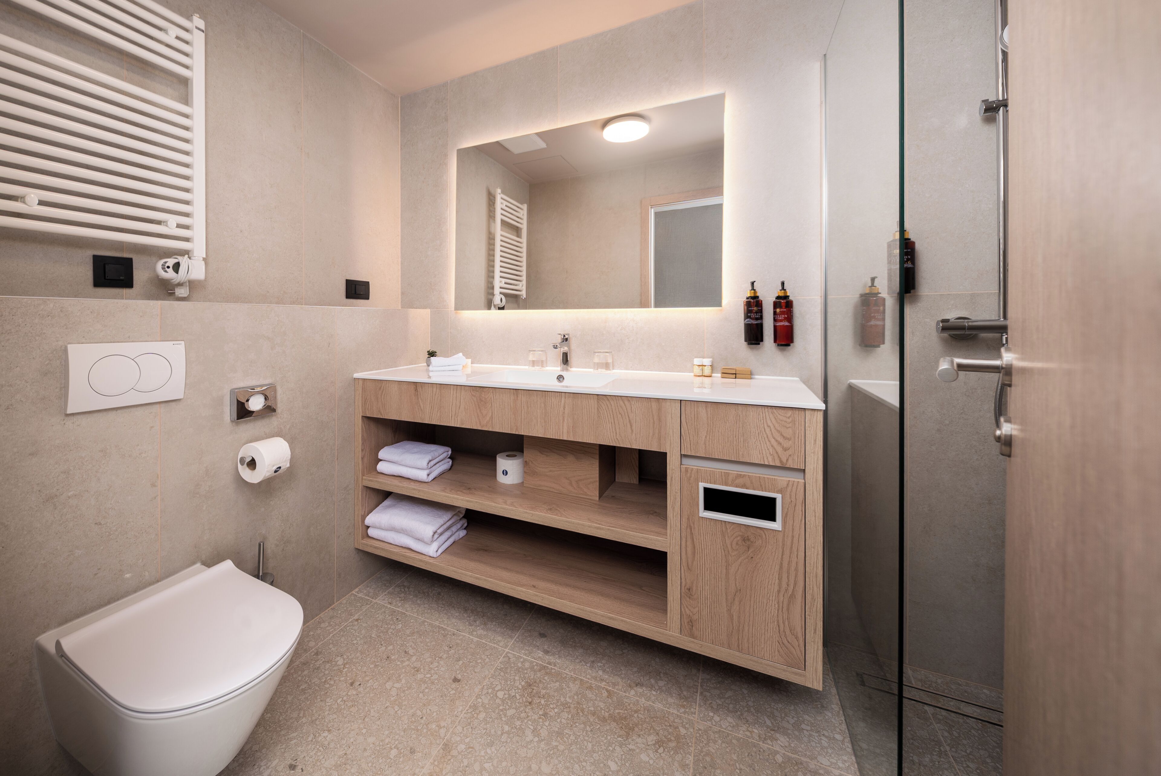 Un bagno moderno con un mobile bagno in legno, un water e uno spazio doccia.