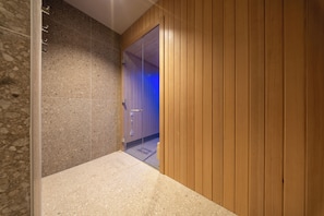 A hallway with a stone wall on one side and wooden paneling on the other, leading to a room with a door. - Family Hotel Adria (Biograd na Moru)