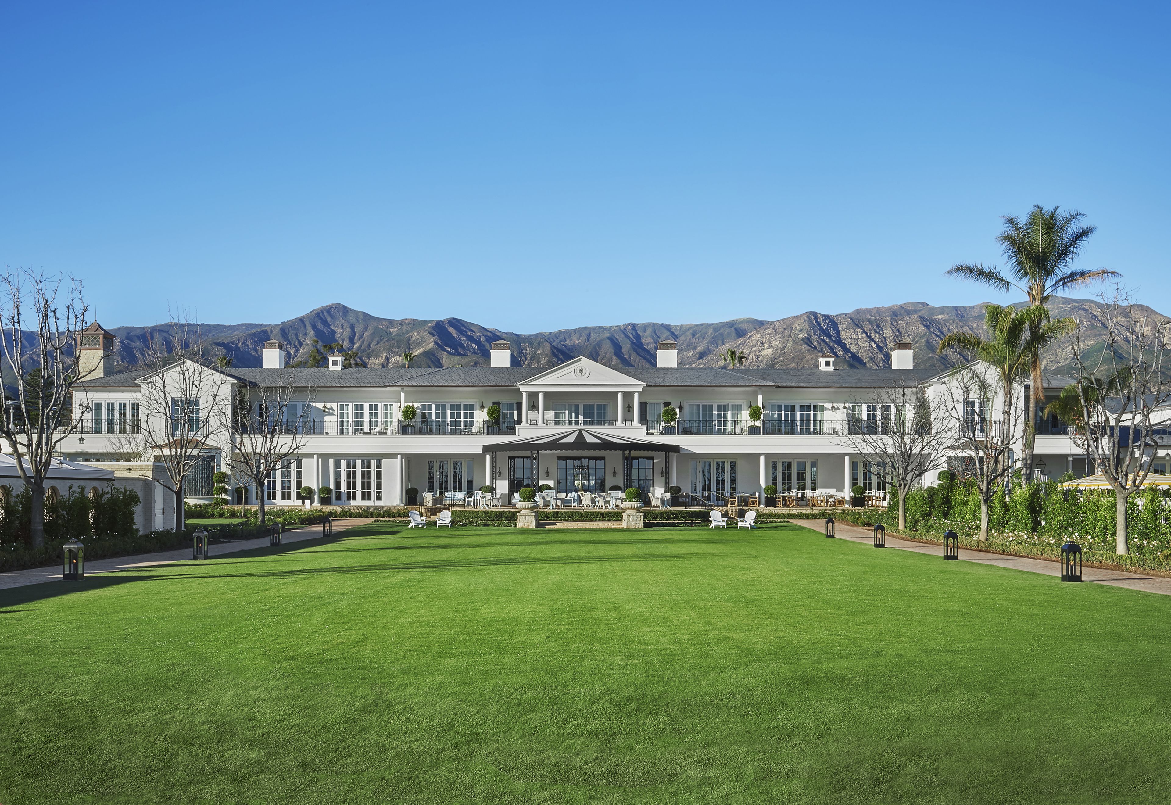 A large, multi-story building with a symmetrical facade, a central entrance with a portico, and a well-maintained lawn in front.