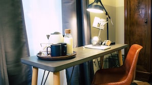 A small table with a lamp, a notebook, and a cup of coffee. - Arsenale Suites (Verona)