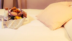 A hotel room with a bed, a basket of food, and two posters on the wall. - Arsenale Suites (Verona)
