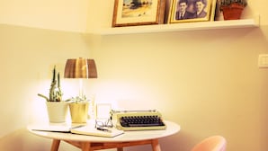 A small, neatly arranged workspace with a typewriter, a lamp, and a chair. - Arsenale Suites (Verona)