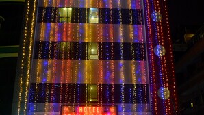 A hotel facade with vertical light strings and a sign reading "ABHINANDAN INN". - Hotel Abhinandan Inn Jaipur (Jaipur)