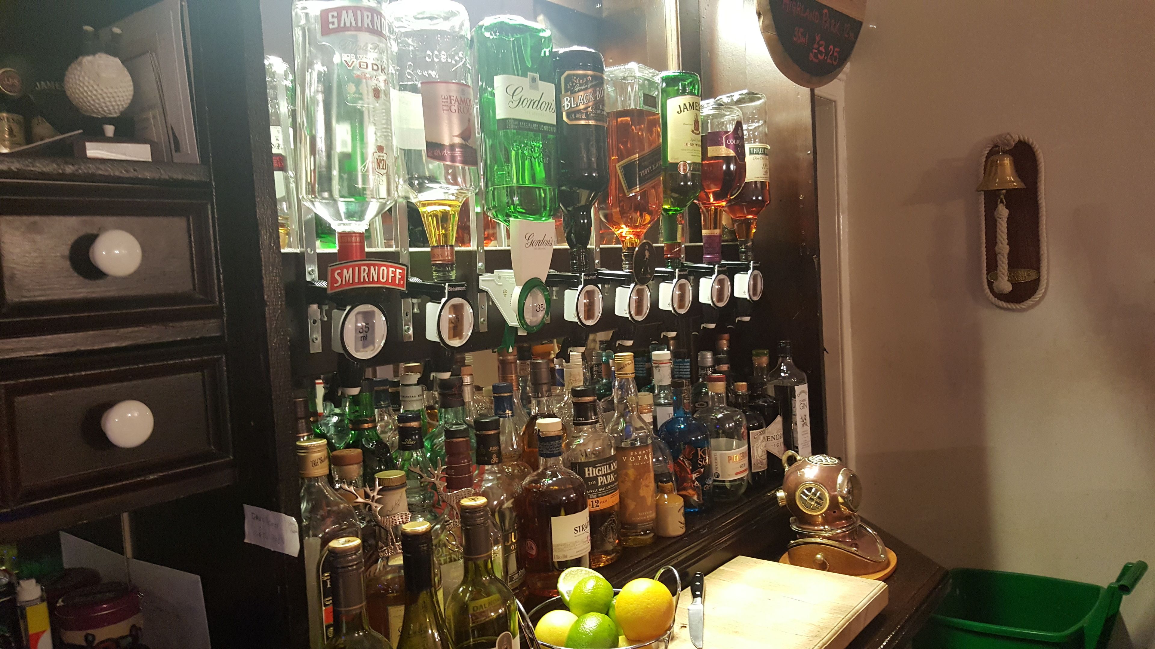 A bar area with various liquor bottles and a selection of citrus fruits.