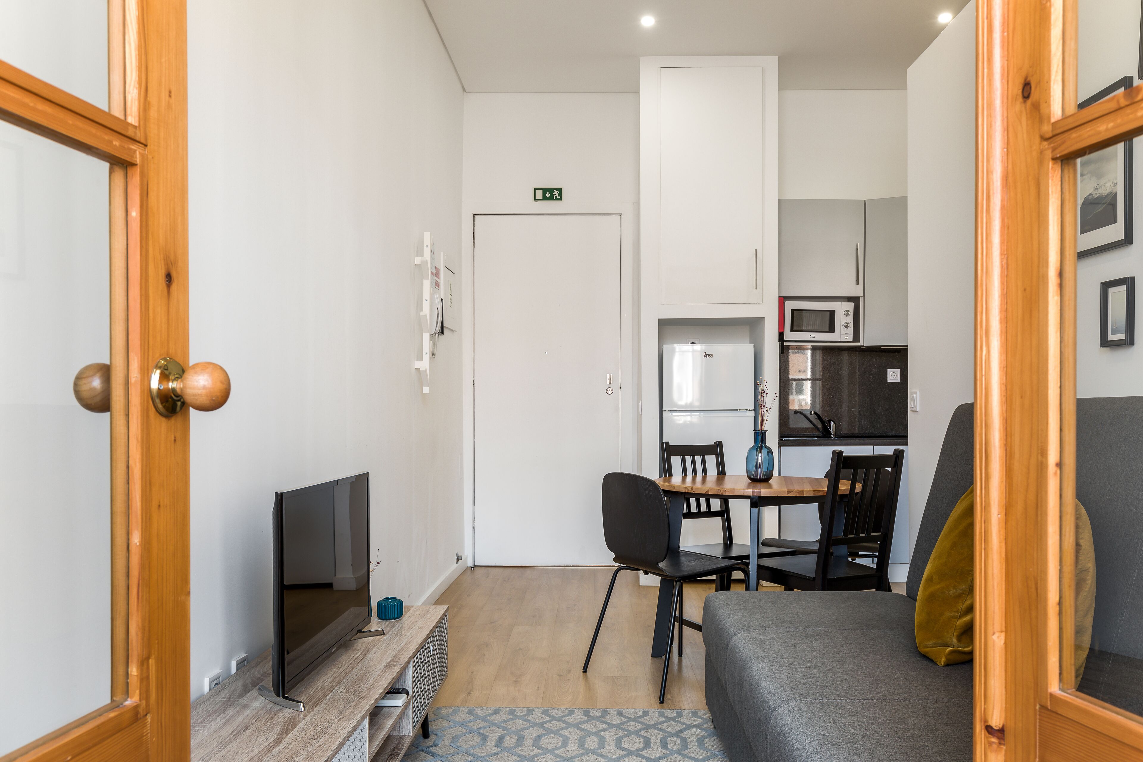 Un espacio habitable compacto con kitchenette, comedor y zona de estar.