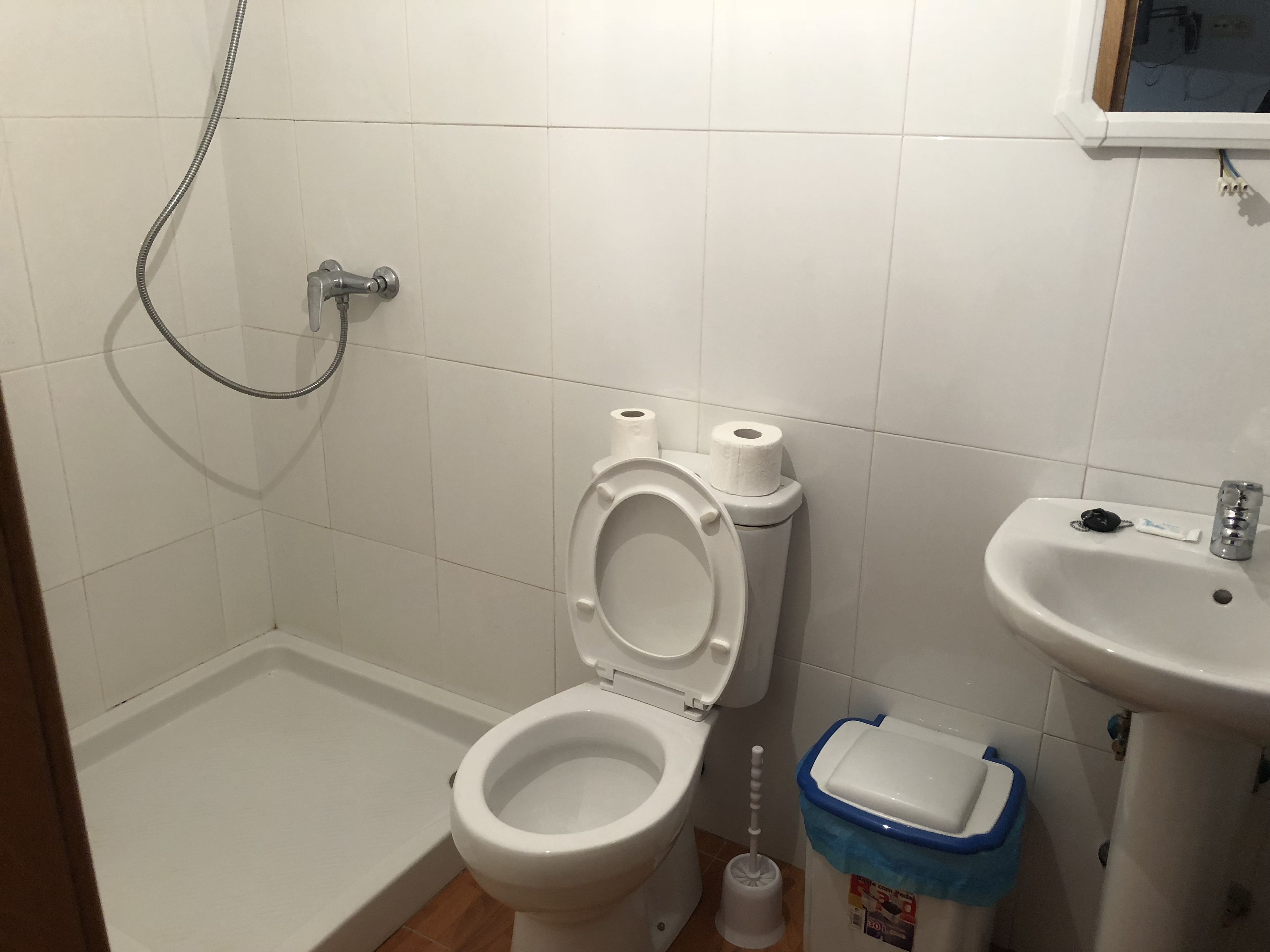Un baño con inodoro, bidé, lavabo y un cubo de basura.