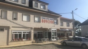 Un edificio con un letrero que dice "BAYONA" y un rótulo de restaurante sobre la entrada.