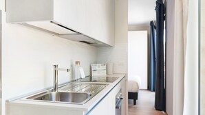 A modern kitchen with a stainless steel sink, a built-in range hood, and a countertop with a bottle and a box. - Italianway   - Bergonzoli (Milan)