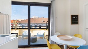 A modern room with a sliding glass door leading to a balcony, a small round table with a tray, and a chair. - Italianway   - Bergonzoli (Milan)