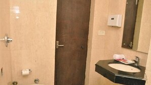 A bathroom with a toilet, sink, and a mirror. - Hotel 42 (Amritsar)