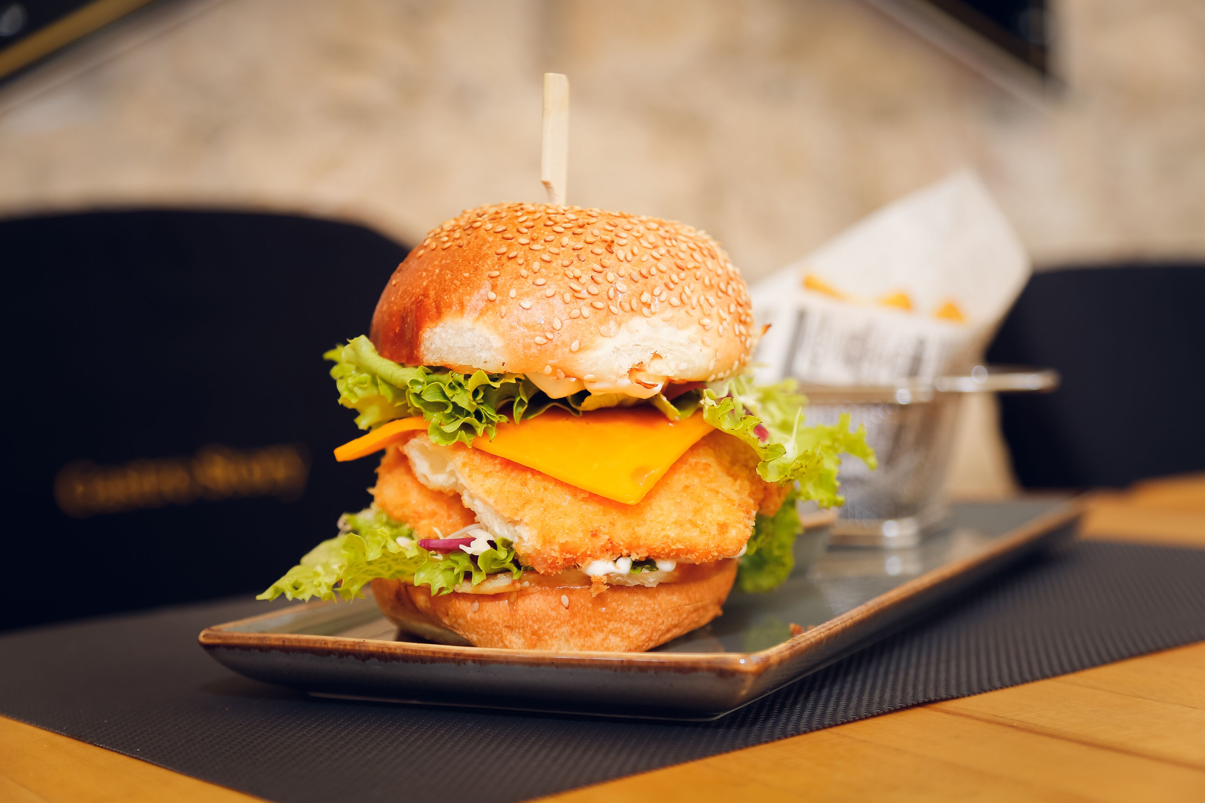 A burger with lettuce, cheese, and a bun on a plate.