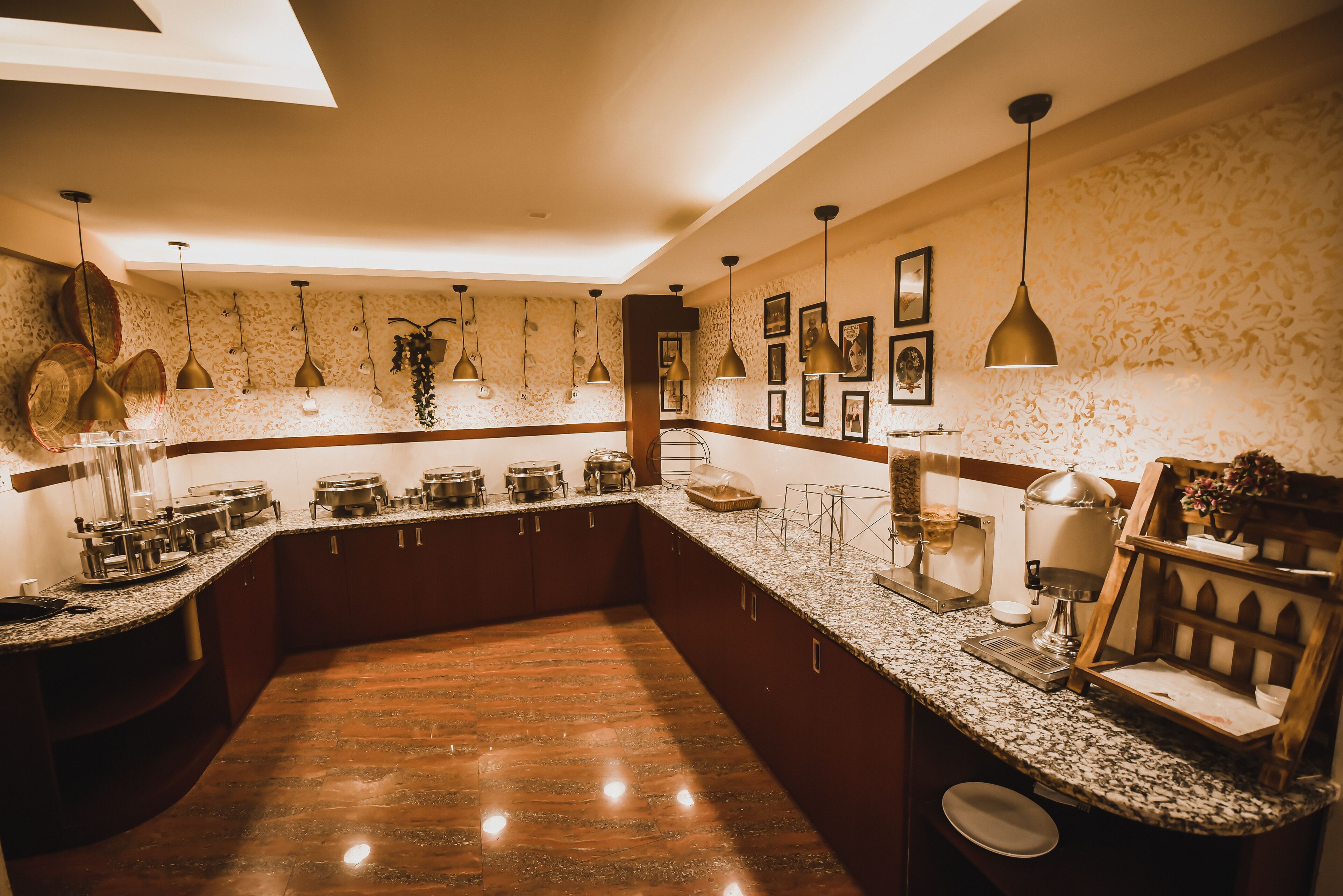 Una cocina con encimeras de granito, electrodomésticos de acero inoxidable, lámparas colgantes y una isla de madera.