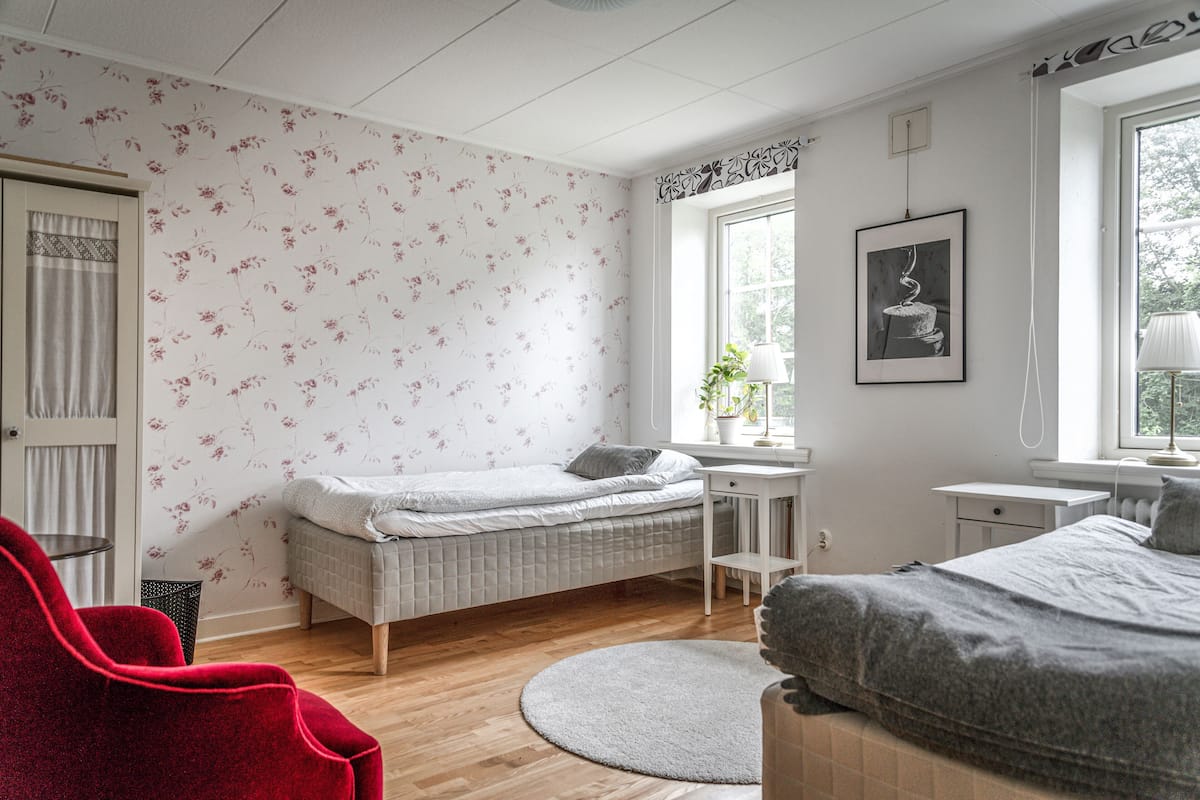 Ein Schlafzimmer mit Bett, Schreibtisch, Stuhl und Fenster.