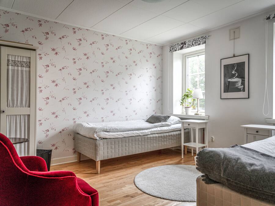 Un dormitorio con cama, escritorio, silla y ventana.