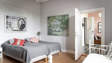 A bedroom with a bed, a nightstand, a lamp, and two paintings on the wall.