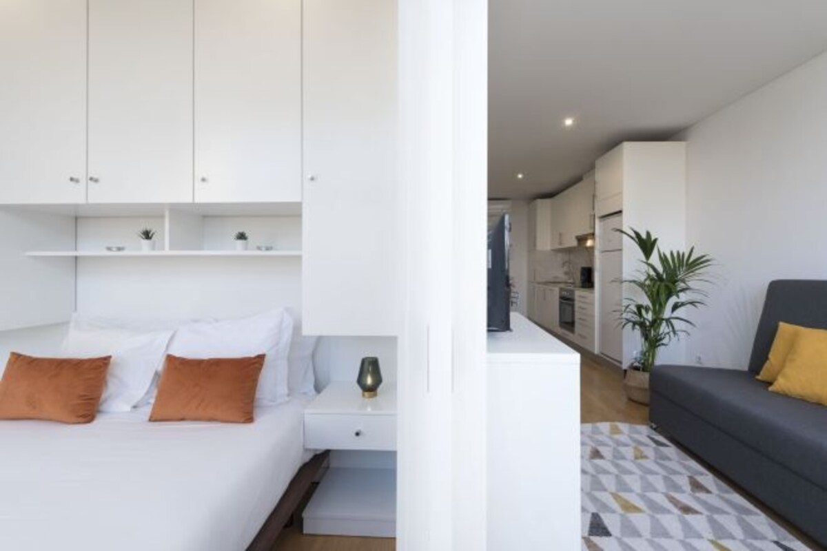 A modern bedroom with a bed, nightstand, and built-in wardrobe.