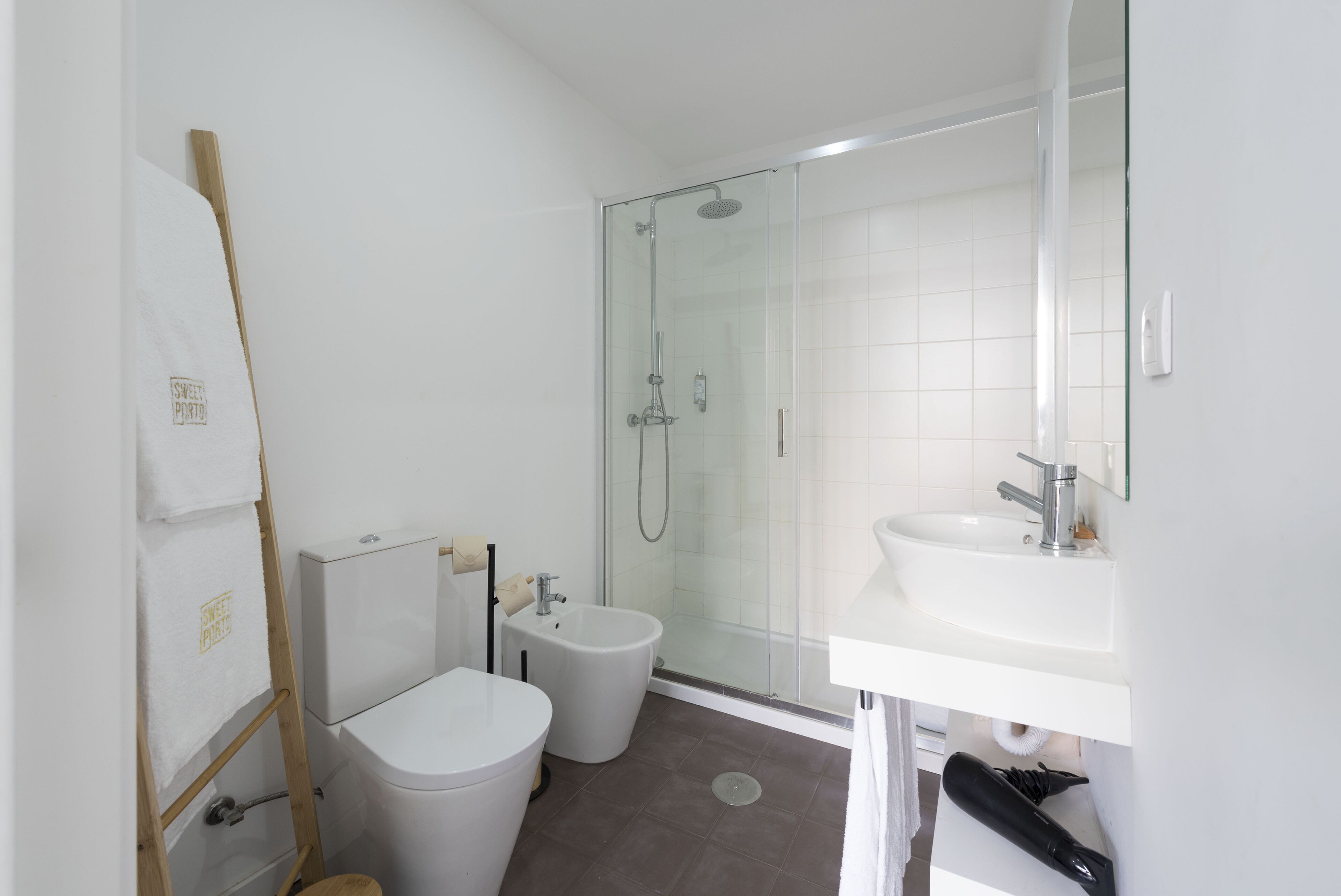 Une salle de bain moderne avec une douche à parois de verre, un lavabo blanc et des toilettes.