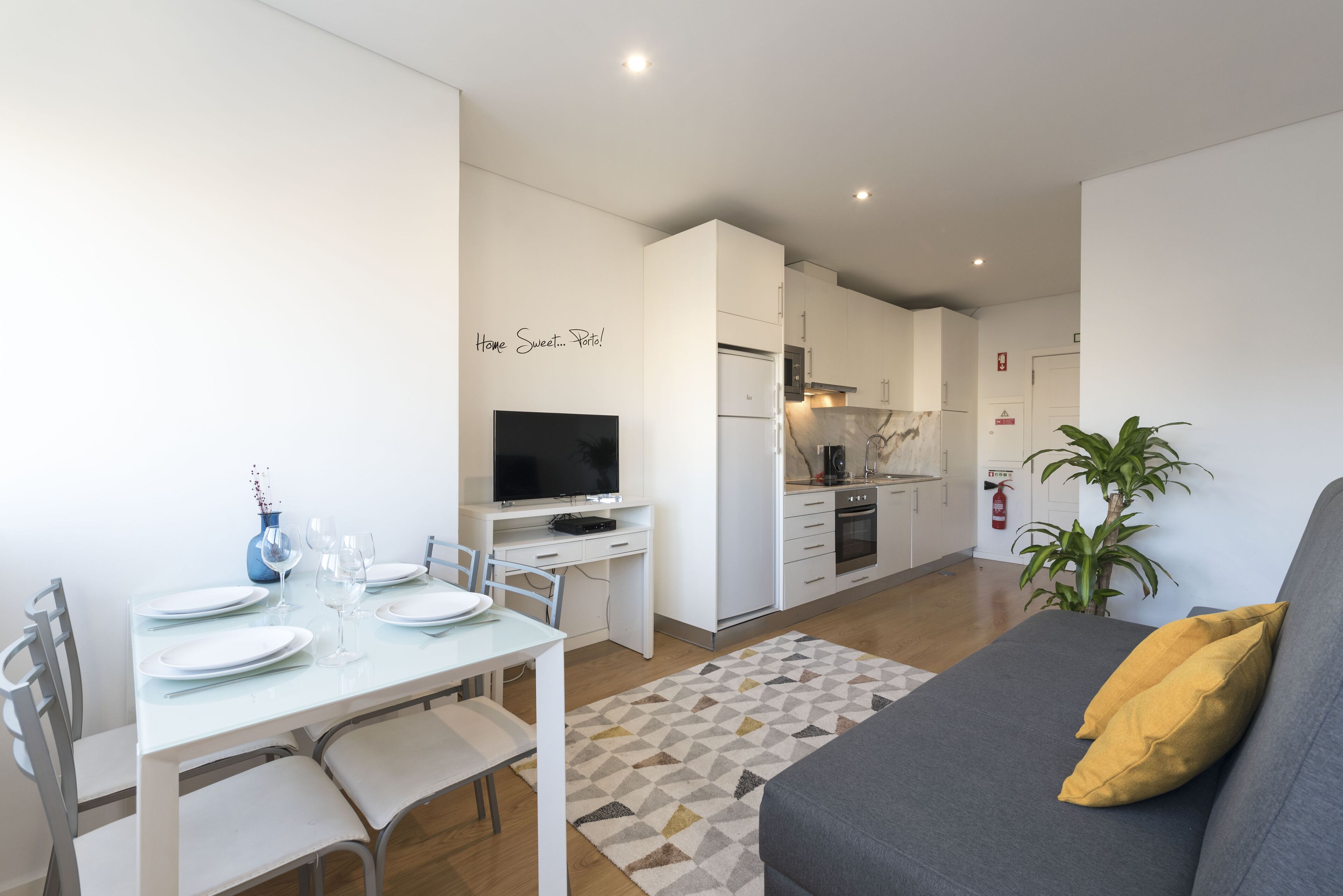 A modern apartment with a dining area, kitchen, and living room.