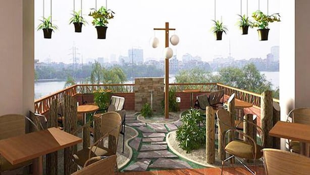 Una terraza con asientos al aire libre, plantas en macetas y vistas a la ciudad.