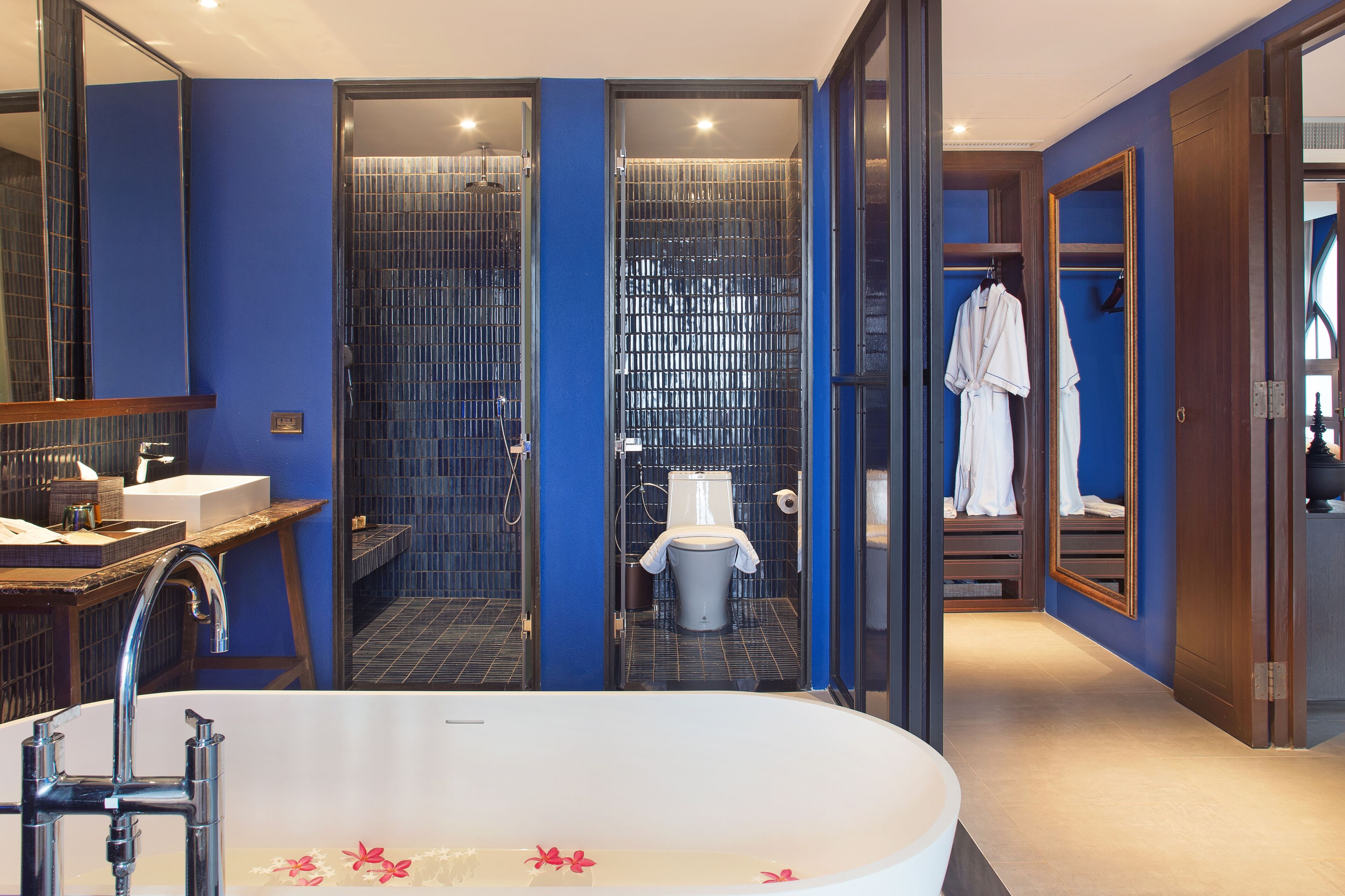 A modern bathroom with a large bathtub, a shower enclosure, and a walk-in closet.
