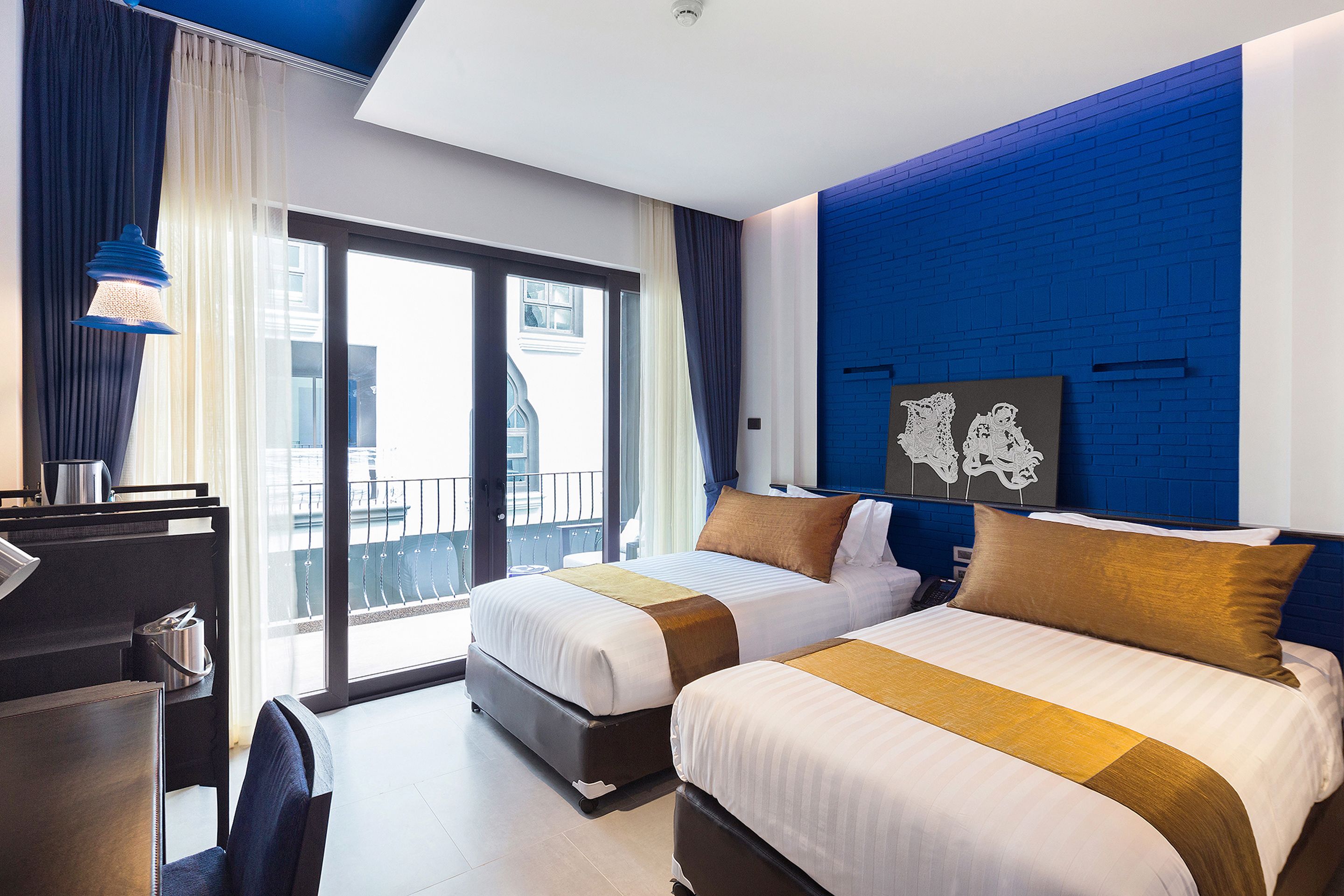 Habitación de hotel con dos camas, un escritorio y vista a la ciudad.