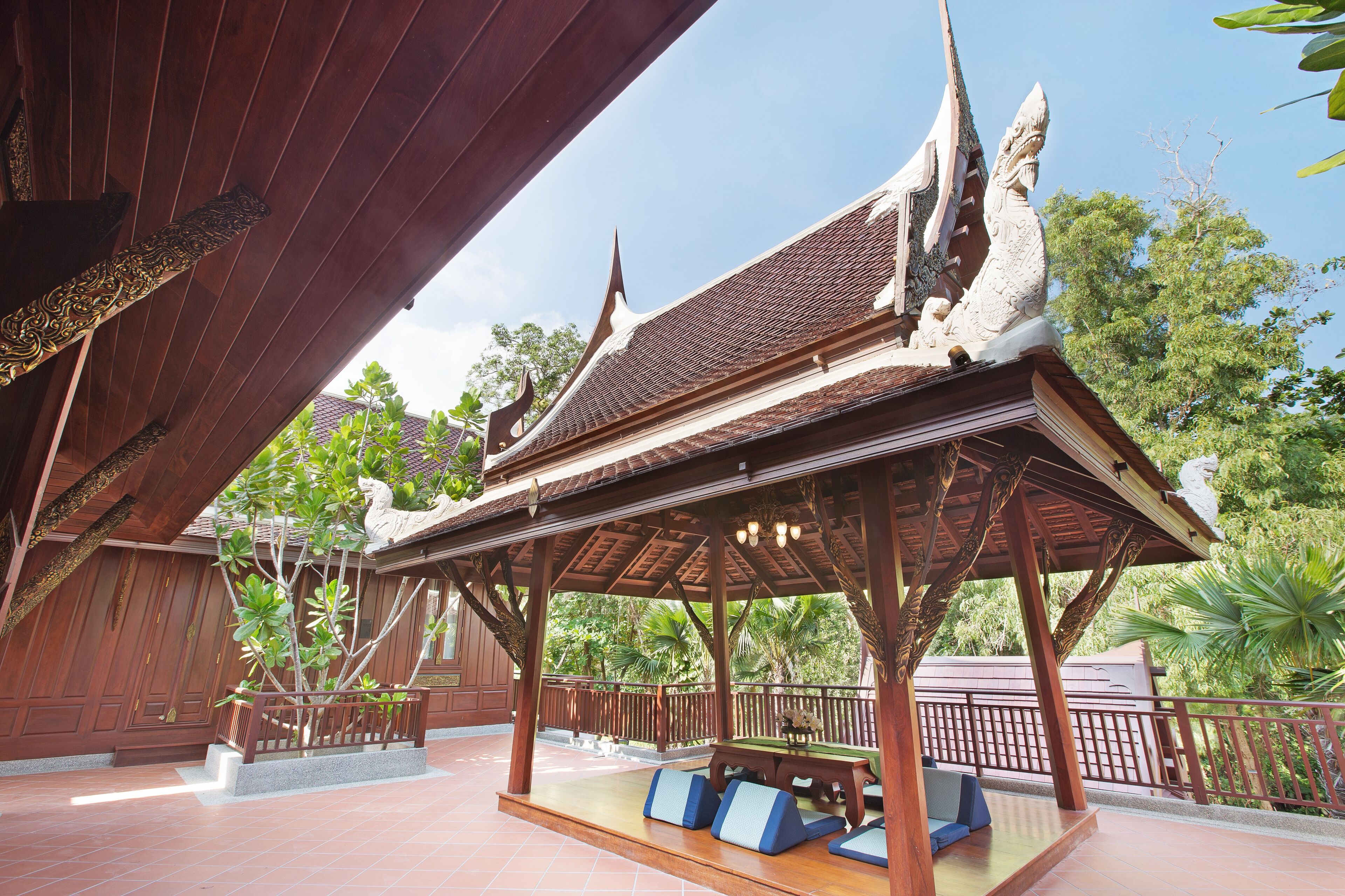 A traditional wooden pavilion with a tiled roof and a bench area.