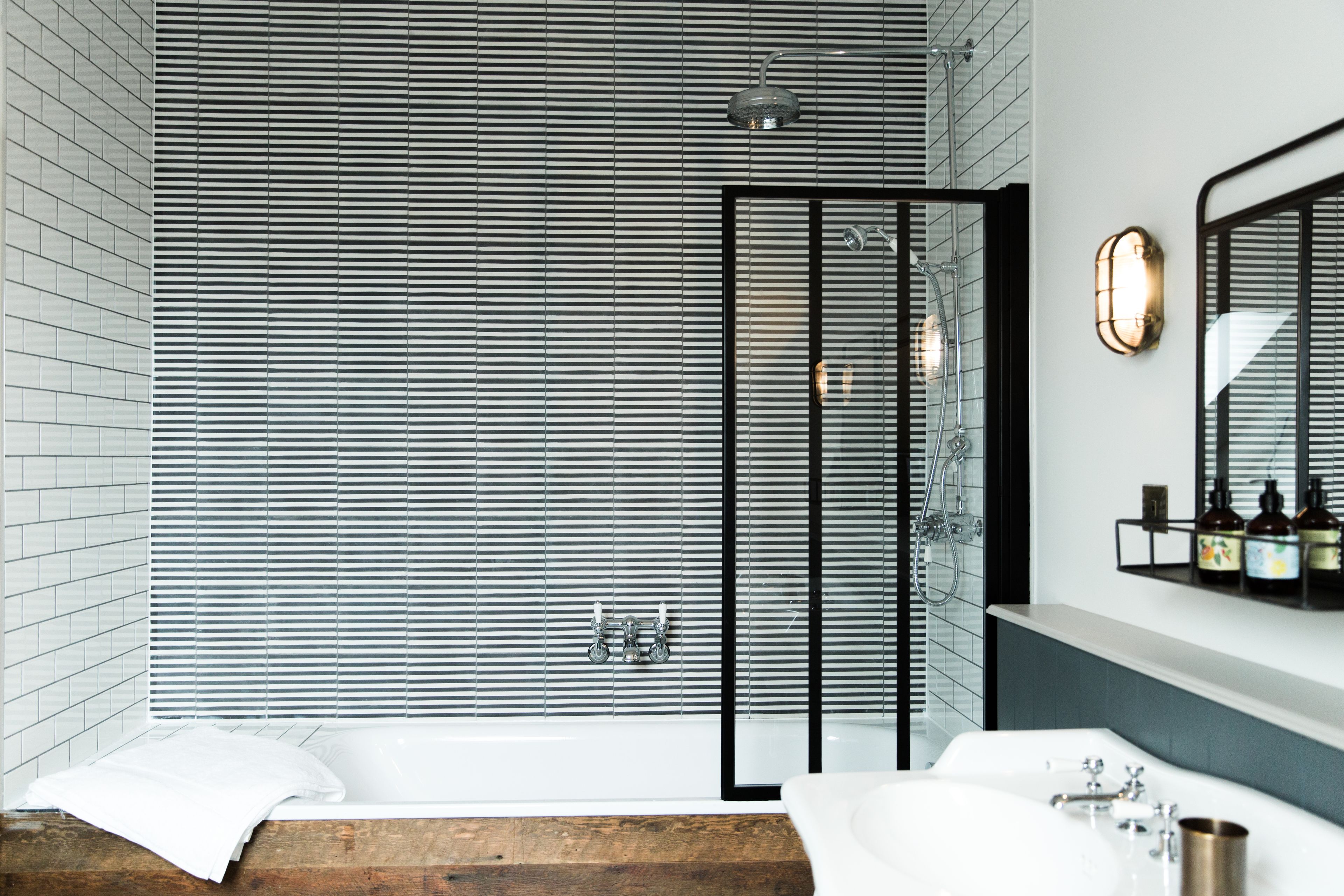 Un baño moderno con una bañera grande, zona de ducha y tocador con espejo.