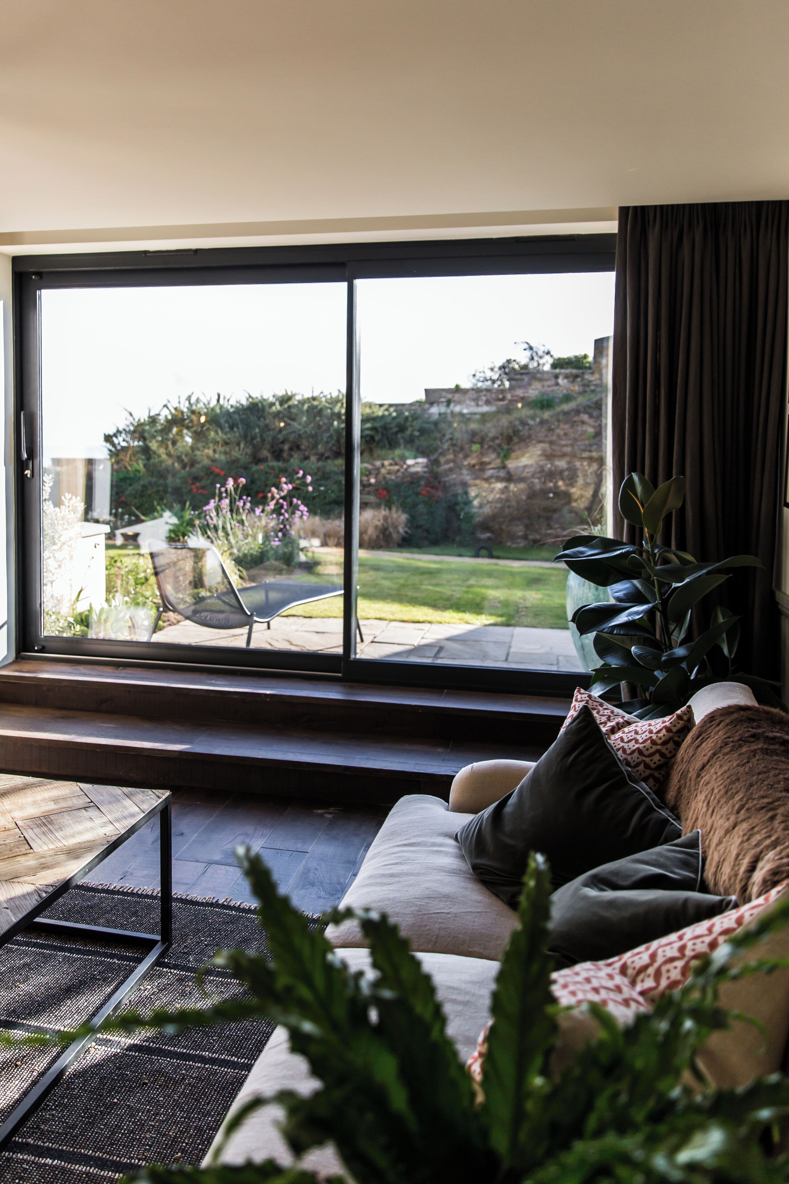 A modern living room with a large sliding glass door leading to a patio.