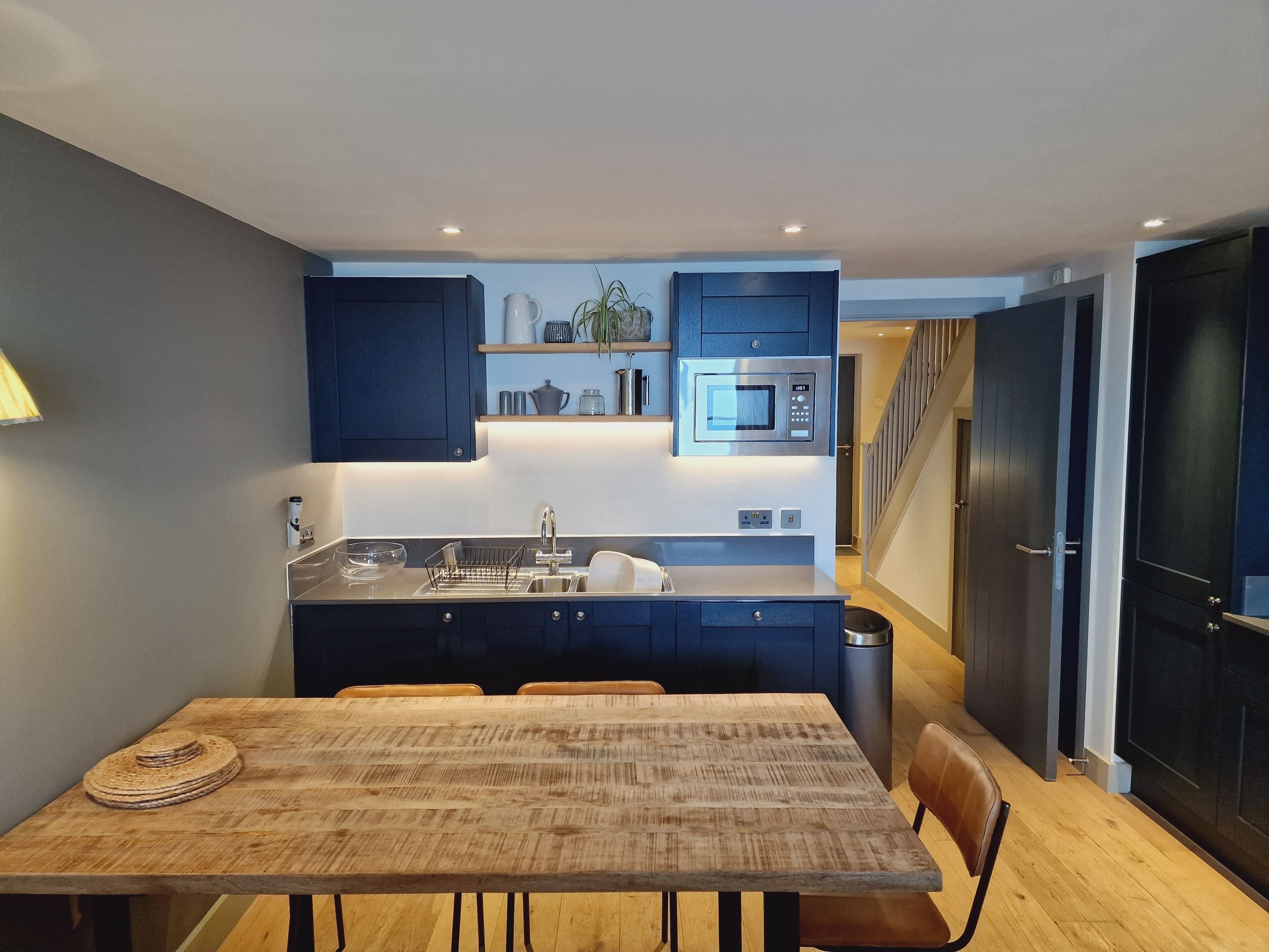 A compact kitchen with dark cabinets, a built-in microwave, and a sink.