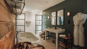 A bathroom with a freestanding bathtub, a sink, and a mirror.