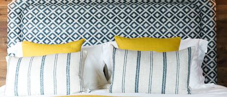 A bed with patterned bedding and pillows.