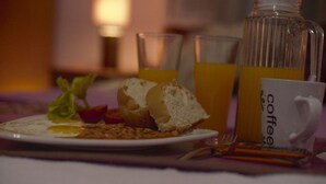Un esmorzar preparat, amb un plat de menjar, una tassa de cafè i un got de suc d'aranja.