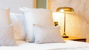 Ein Bett mit vier Kissen und einer Nachttischlampe.