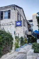 A stone building with a 'City Port' sign, potted plants, and a stone pathway.