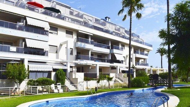 Un hôtel à plusieurs étages doté de balcons, d’une piscine et d’une pelouse bien entretenue.