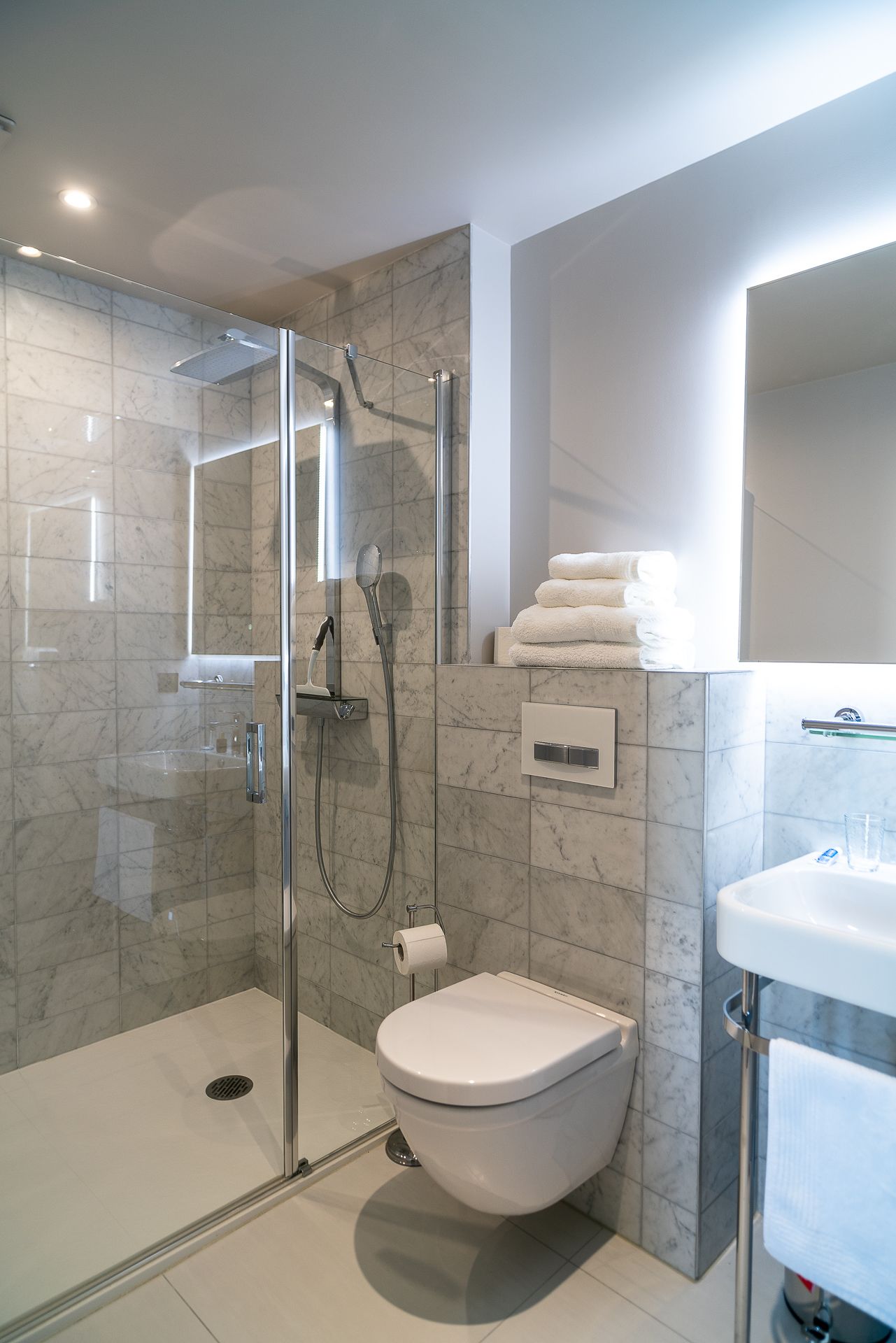 Une salle de bain moderne avec une douche à parois de verre, des toilettes et un lavabo.