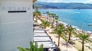 Et strandhotel med udsigt til hav og bjerge.