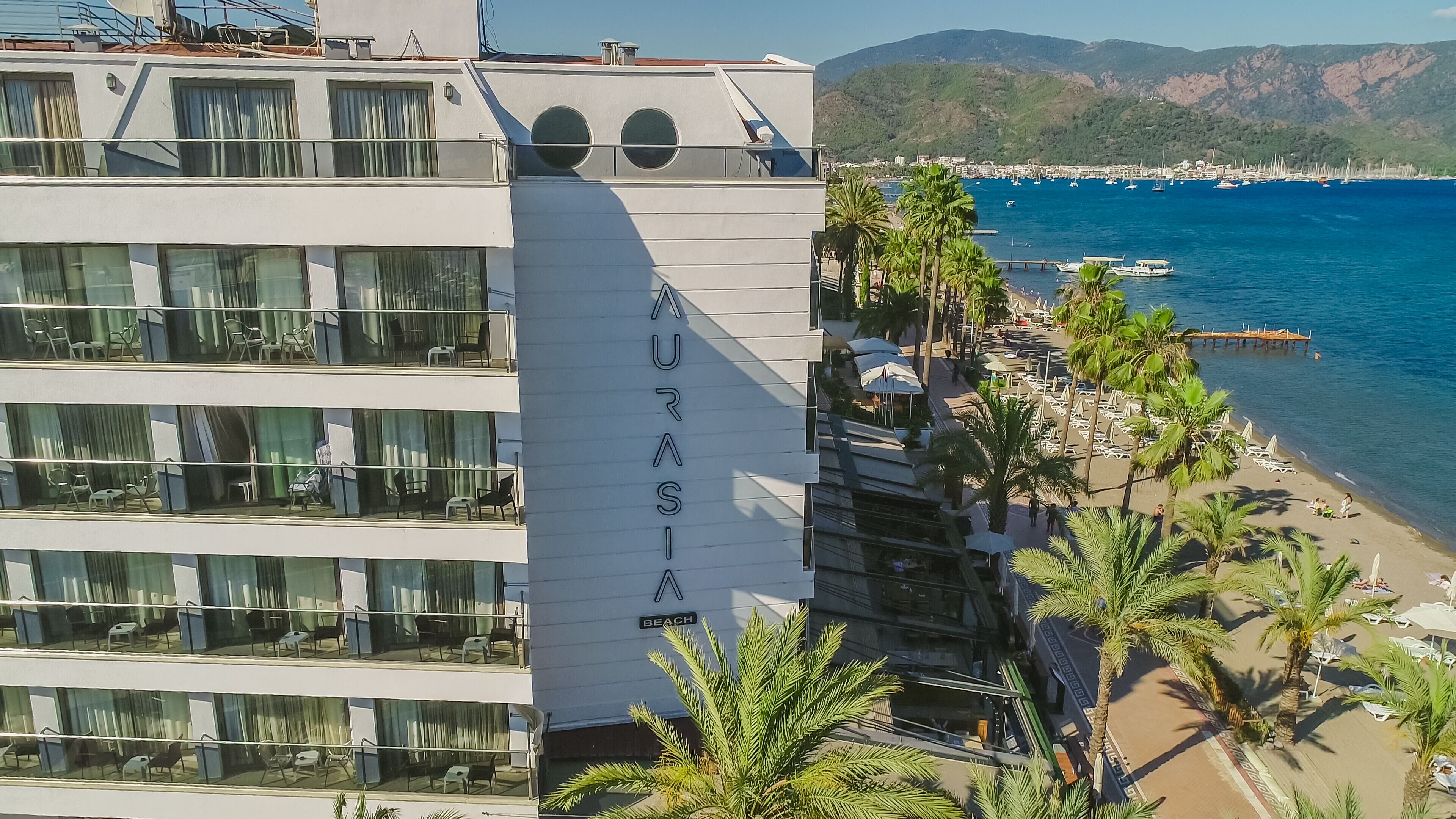 A modern building with balconies and a sign reading "KURASIA BEACH".