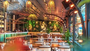 En restaurant med moderne interiør, med hængende lys og et barområde.