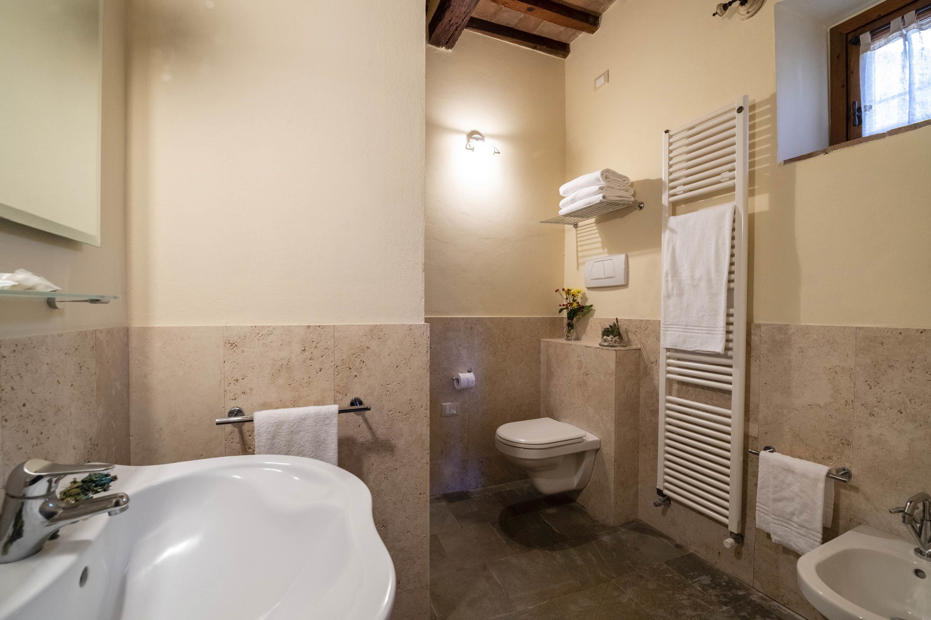 A bathroom with a bathtub, a sink, a toilet, and a towel rack.