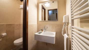 Une petite salle de bain avec des toilettes, un lavabo et un miroir.