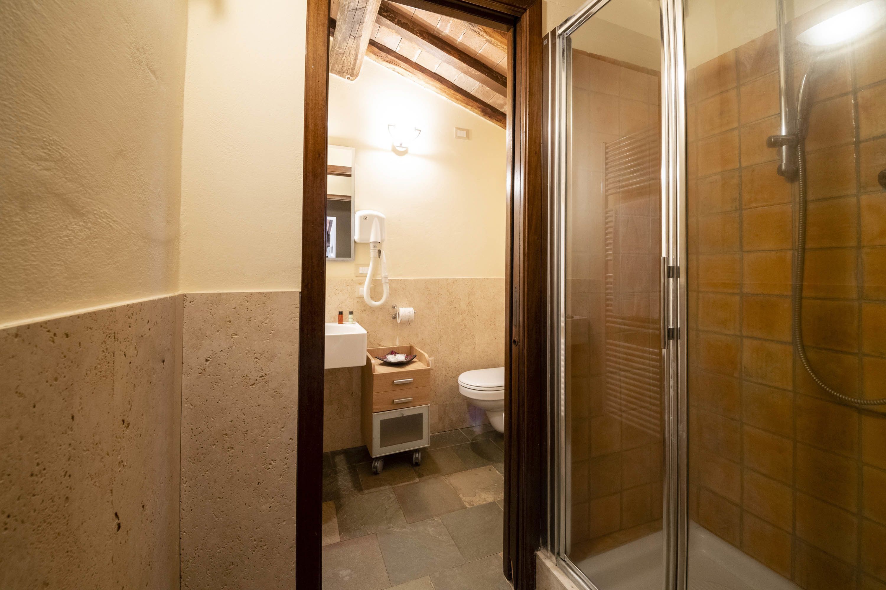 A bathroom with a shower, toilet, and sink.