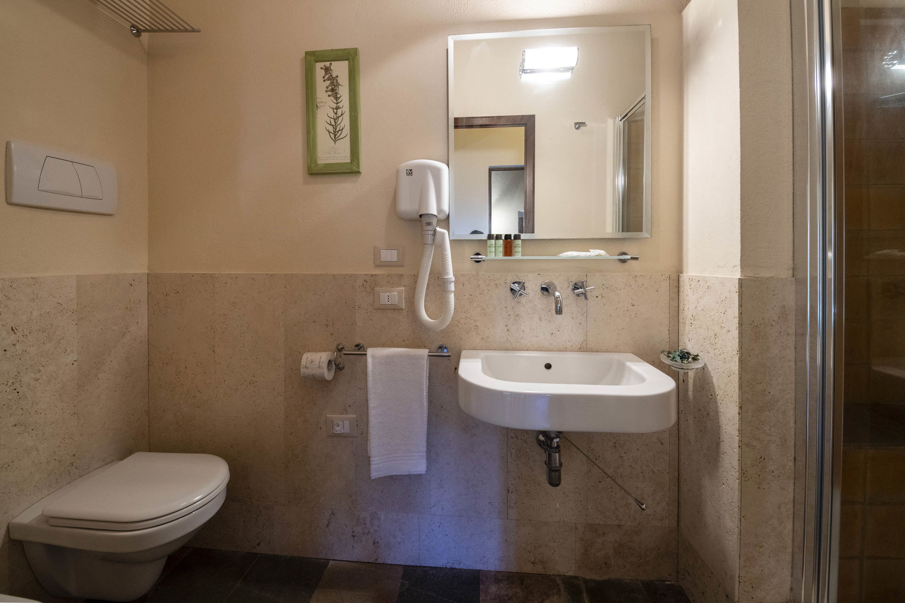 Un baño con inodoro, lavabo y ducha.