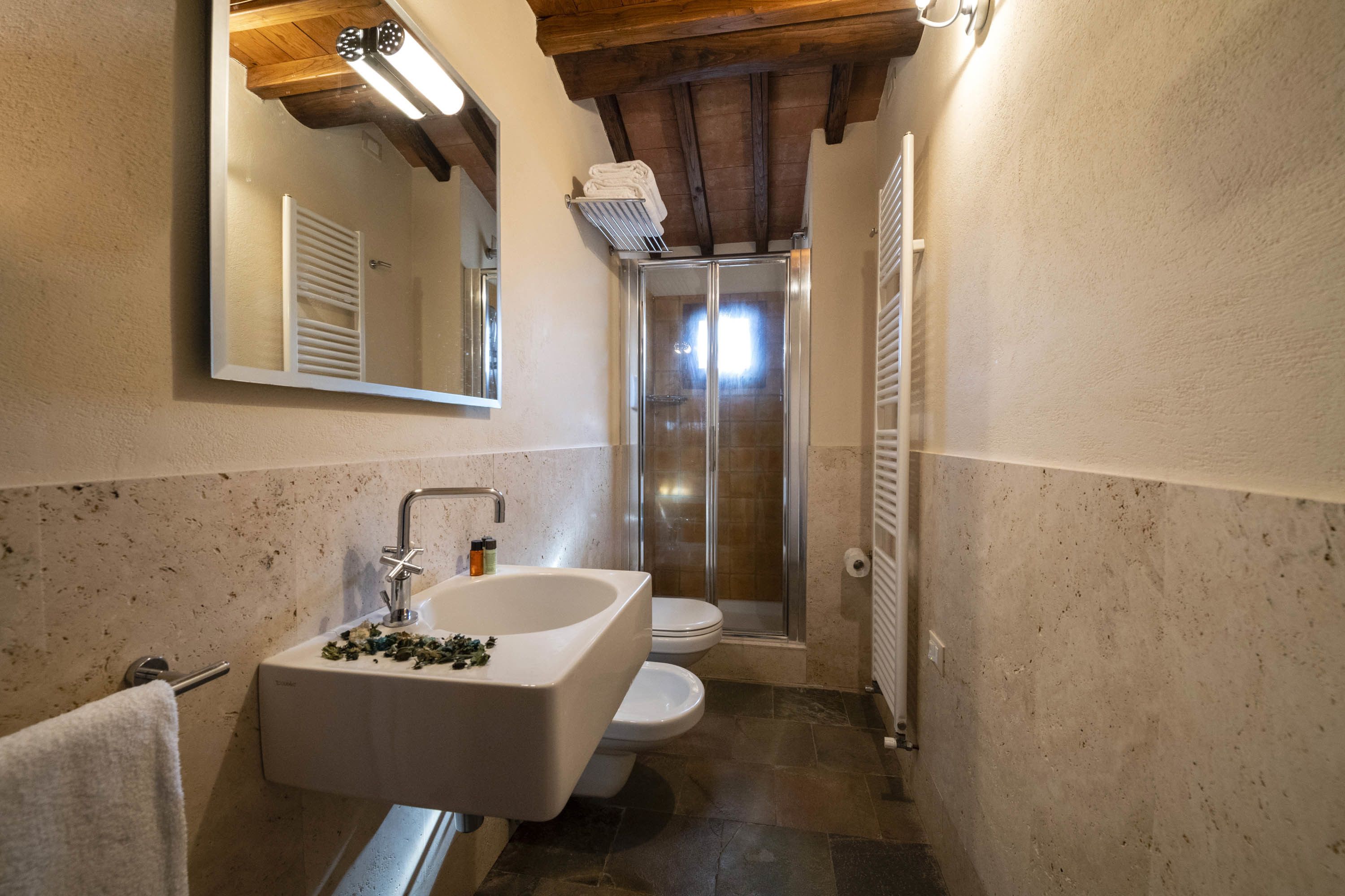 A bathroom with a freestanding bathtub, a toilet, and a glass-enclosed shower.