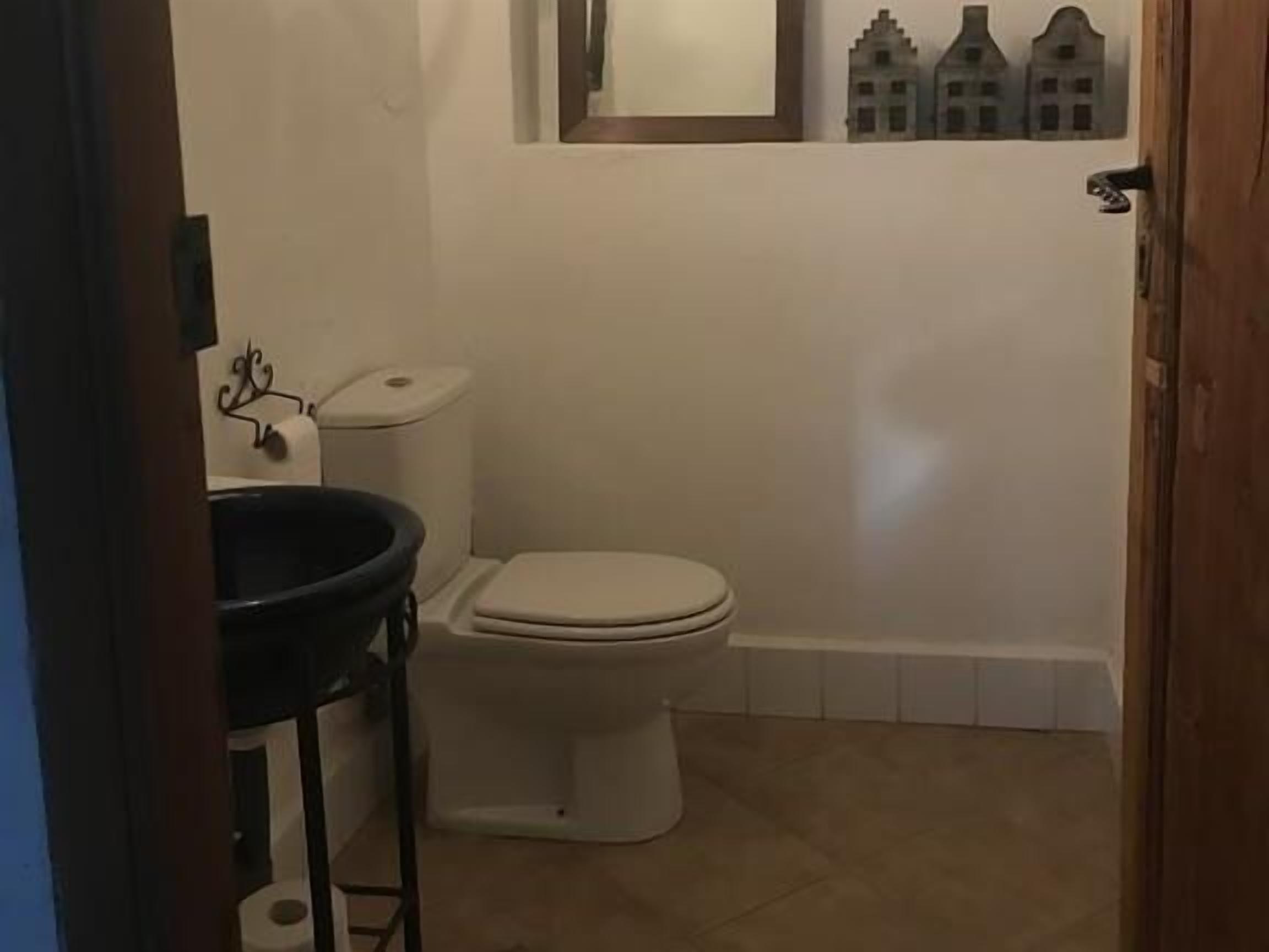 A small bathroom with a toilet, a sink, and a mirror.