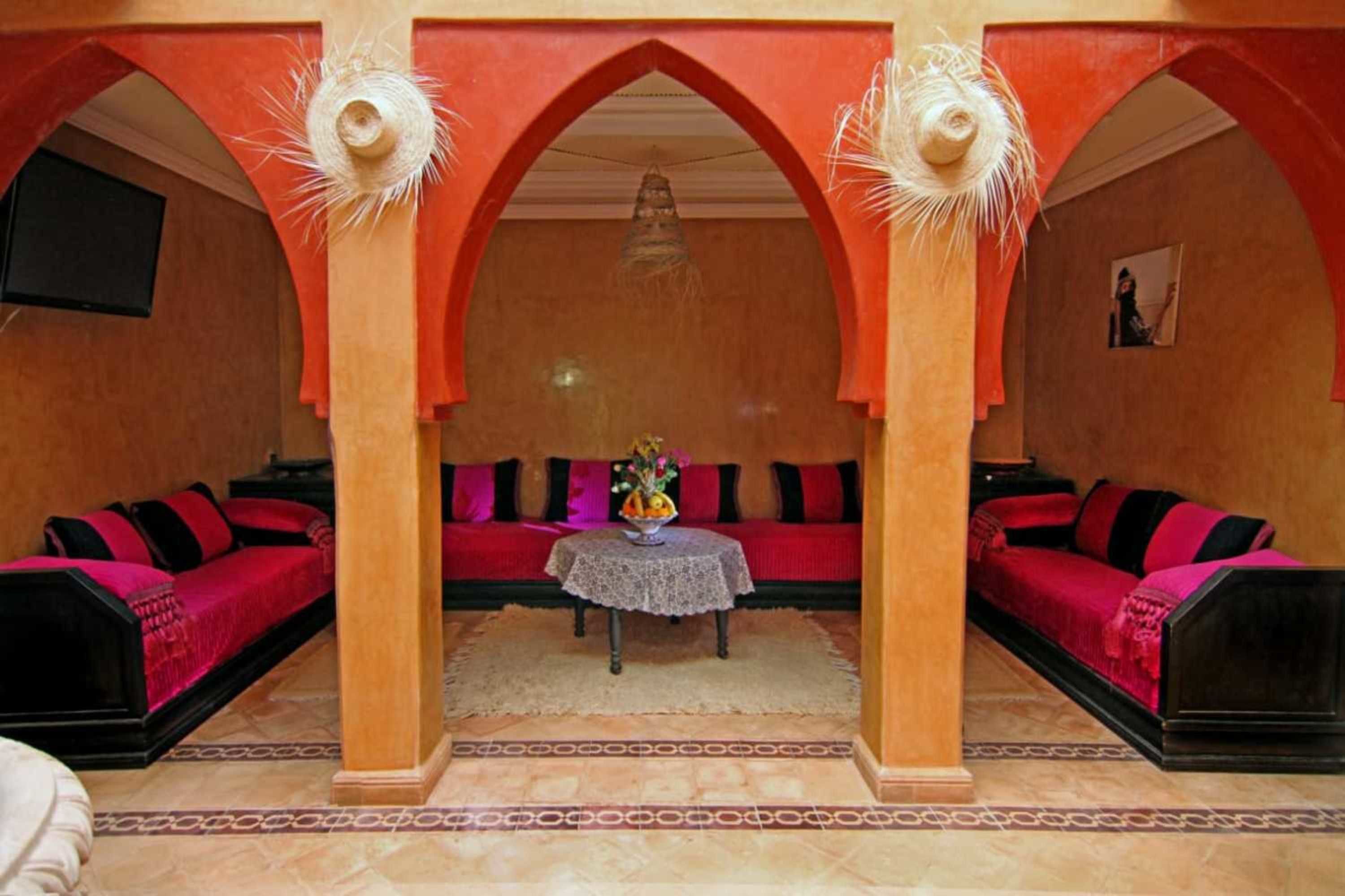 A room with a central seating area, a table with a vase, and a framed picture on the wall.